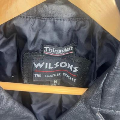 Sale Photo Thumbnail #625: This Wilsons leather motorcycle jacket offers a classic biker look with its durable leather fabric and Thinsulate insulation. Its cropped design and multiple zippered pockets add style and functionality, making it suitable for cool weather rides.

• Zip