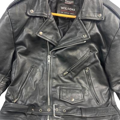 Sale Photo Thumbnail #622: This Wilsons leather motorcycle jacket offers a classic biker look with its durable leather fabric and Thinsulate insulation. Its cropped design and multiple zippered pockets add style and functionality, making it suitable for cool weather rides.

• Zip