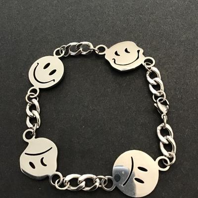 Silver tone bracelet with face charms