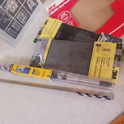 LONG DRILL BITS, VARIETY OF SANDPAPER AND AN INTERIOR DESIGN BOOK