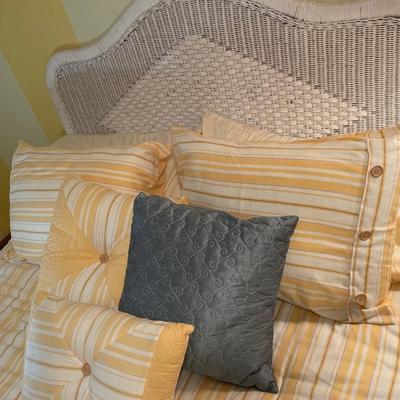 Sunny yellow comforter and white wicker headboard with mattress