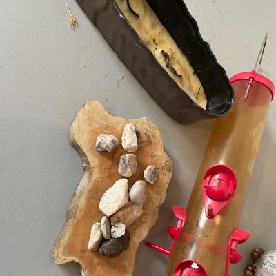 Two outdoor birds, bird feeder, rocks and wood