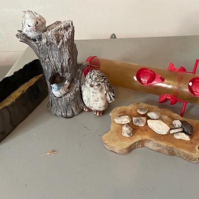 Two outdoor birds, bird feeder, rocks and wood