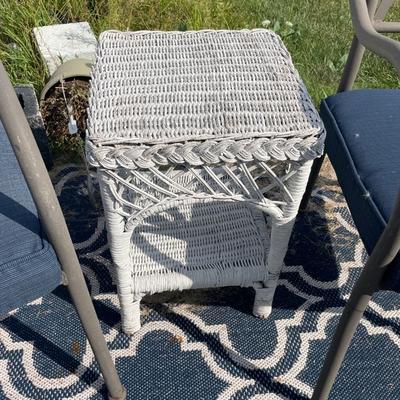 2 brown chairs with wicker table