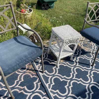 2 brown chairs with wicker table