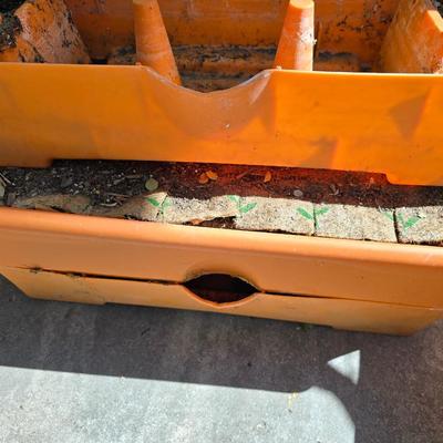 Three large orangish colored planters with tomato walls - self watering basin!