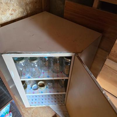 Metal corner cabinet full of mason jars