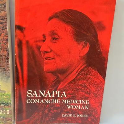 Native American books with a dream catcher, pottery and a native scraper tool