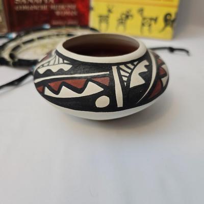 Native American books with a dream catcher, pottery and a native scraper tool