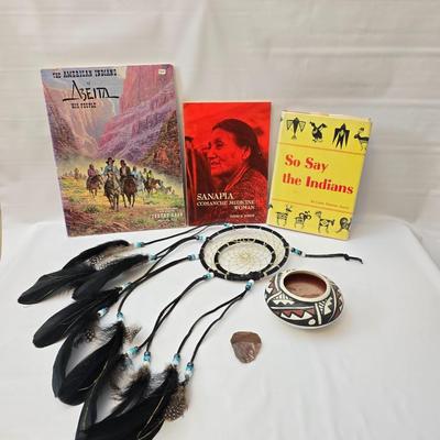 Native American books with a dream catcher, pottery and a native scraper tool