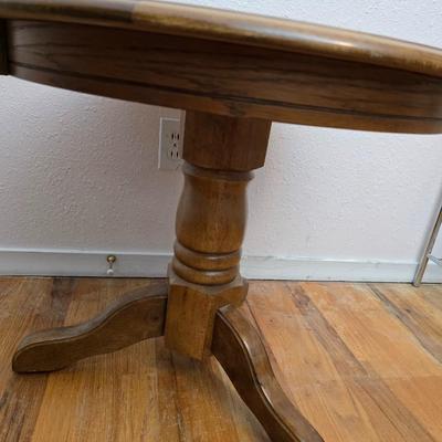 25" Oak claw foot side table with brand new table lamp and a vase with faux flowers