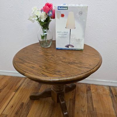 25" Oak claw foot side table with brand new table lamp and a vase with faux flowers