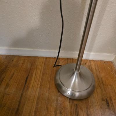 Adjustable armed floor lamp with gold framed wall art pair