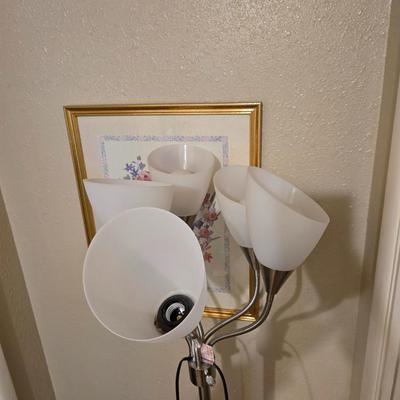 Adjustable armed floor lamp with gold framed wall art pair