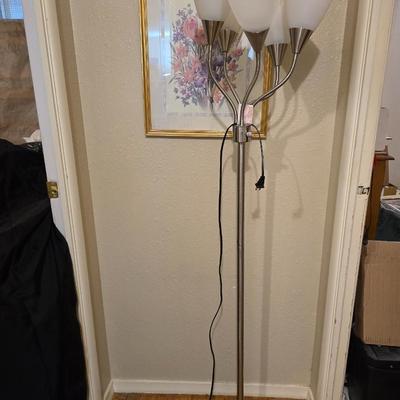 Adjustable armed floor lamp with gold framed wall art pair