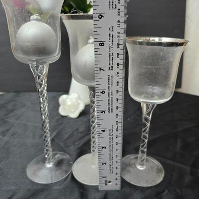 Glass vases and candle holders with boquet of faux flowers