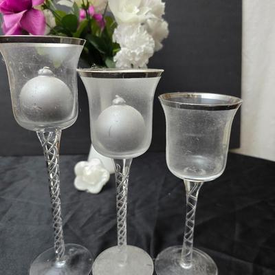 Glass vases and candle holders with boquet of faux flowers
