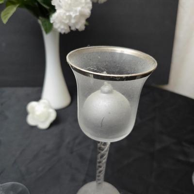 Glass vases and candle holders with boquet of faux flowers
