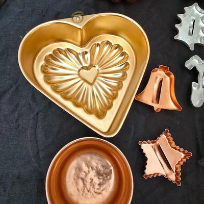 Cookies anyone? Cookie sheet with a large variety of vintage cookie cutters and a Mirror cookie press and copper Jello molds