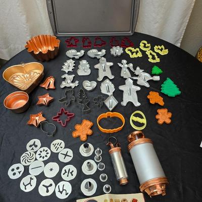 Cookies anyone? Cookie sheet with a large variety of vintage cookie cutters and a Mirror cookie press and copper Jello molds