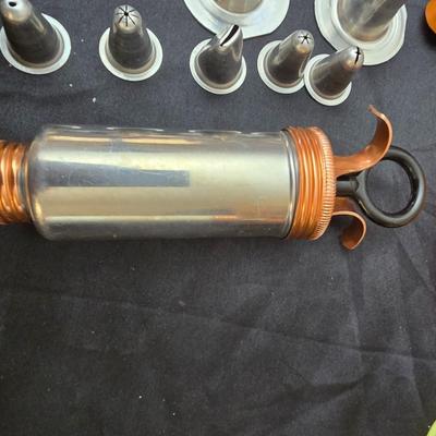 Cookies anyone? Cookie sheet with a large variety of vintage cookie cutters and a Mirror cookie press and copper Jello molds