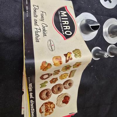 Cookies anyone? Cookie sheet with a large variety of vintage cookie cutters and a Mirror cookie press and copper Jello molds