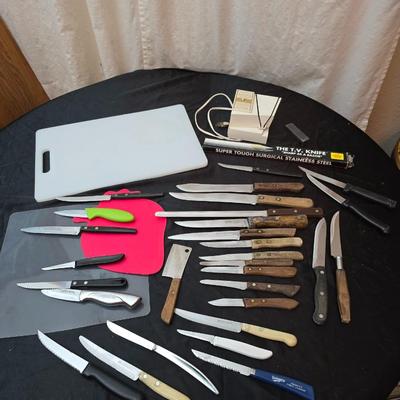 Collection of Kitchen knives, cutting boards, and an electric knife sharppener