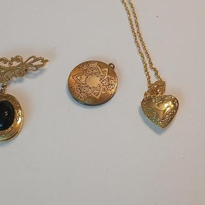 Three gold toned lockets