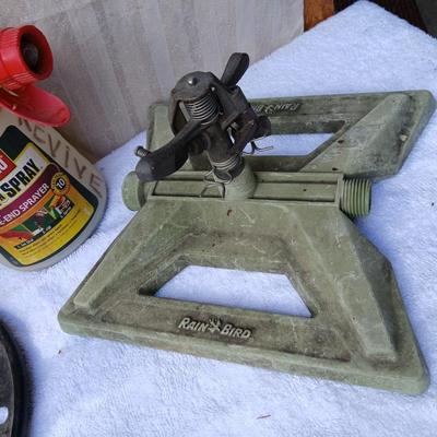 Assortment of yard sprinklers, small hand - tools, and a sprayer