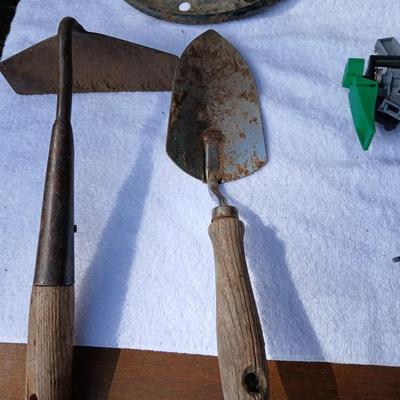 Assortment of yard sprinklers, small hand - tools, and a sprayer