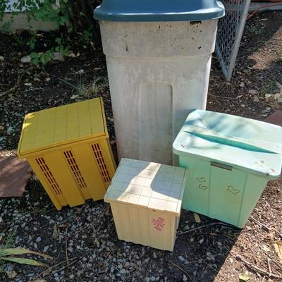 Large sized rolling garbage bin with several smaller plastic trash cans / containers
