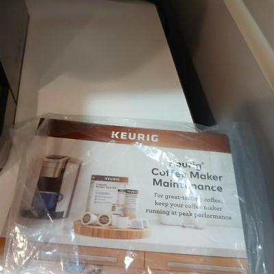 Keurig coffee pot with coffee mugs and other accessories