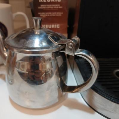 Keurig coffee pot with coffee mugs and other accessories