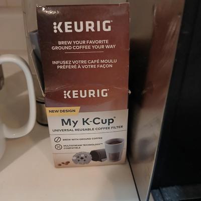 Keurig coffee pot with coffee mugs and other accessories