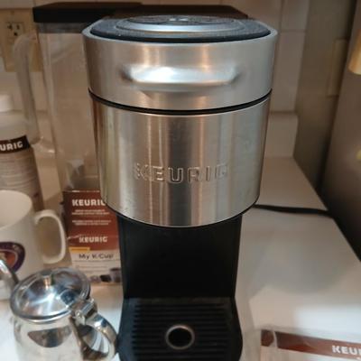 Keurig coffee pot with coffee mugs and other accessories