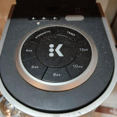 Keurig coffee pot with coffee mugs and other accessories
