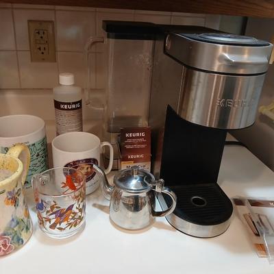 Keurig coffee pot with coffee mugs and other accessories