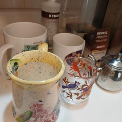 Keurig coffee pot with coffee mugs and other accessories