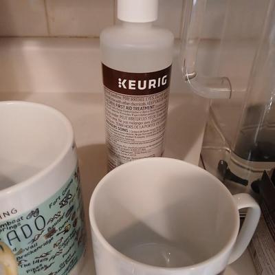 Keurig coffee pot with coffee mugs and other accessories