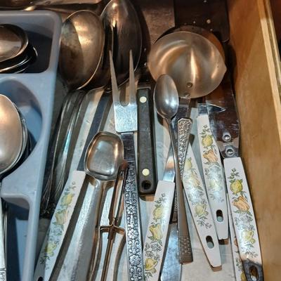 Drawer organizer full of assorted mis-matched flatware and a nice utensil set
