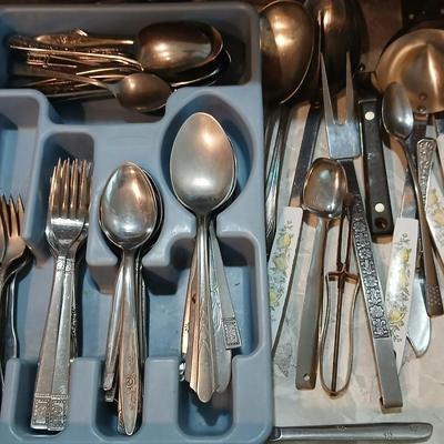 Drawer organizer full of assorted mis-matched flatware and a nice utensil set