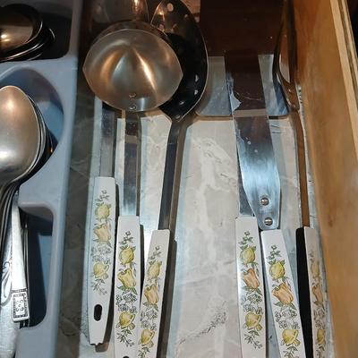 Drawer organizer full of assorted mis-matched flatware and a nice utensil set