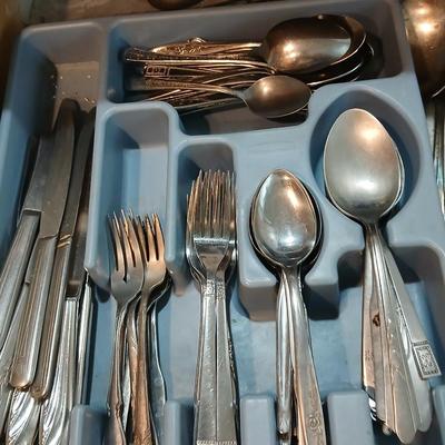 Drawer organizer full of assorted mis-matched flatware and a nice utensil set