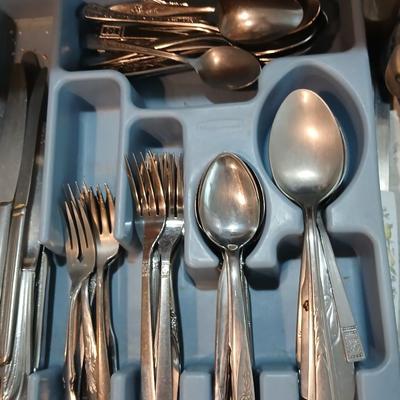 Drawer organizer full of assorted mis-matched flatware and a nice utensil set