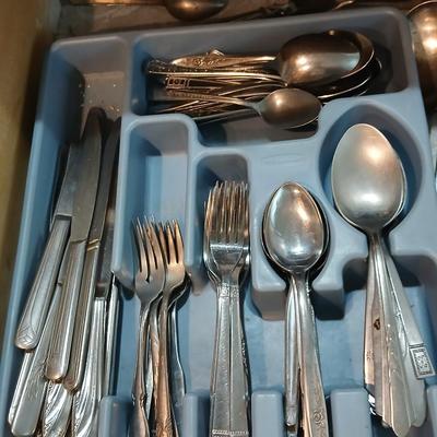 Drawer organizer full of assorted mis-matched flatware and a nice utensil set