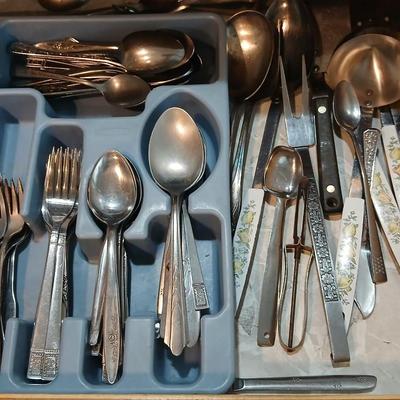 Drawer organizer full of assorted mis-matched flatware and a nice utensil set