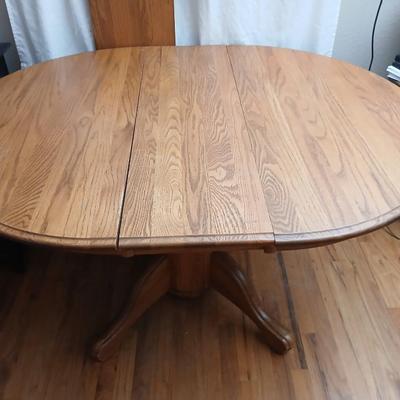 Oak diningroom table with claw foot base - 4 fabric covered chairs and two table leafs.