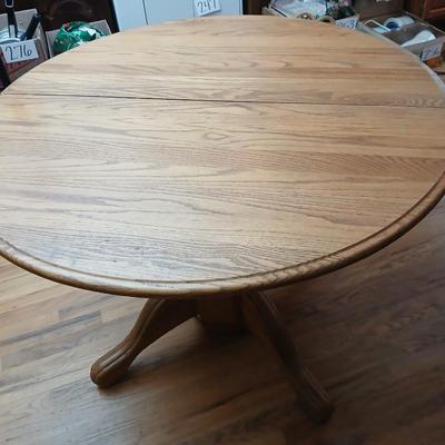 Oak diningroom table with claw foot base - 4 fabric covered chairs and two table leafs.