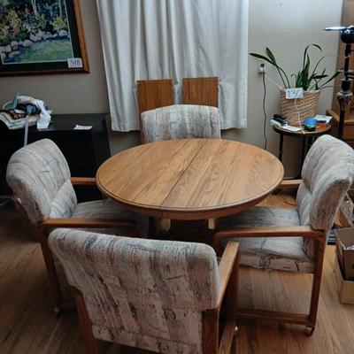 Oak diningroom table with claw foot base - 4 fabric covered chairs and two table leafs.