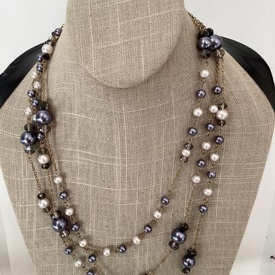 Multi strand necklace with purple and white beads